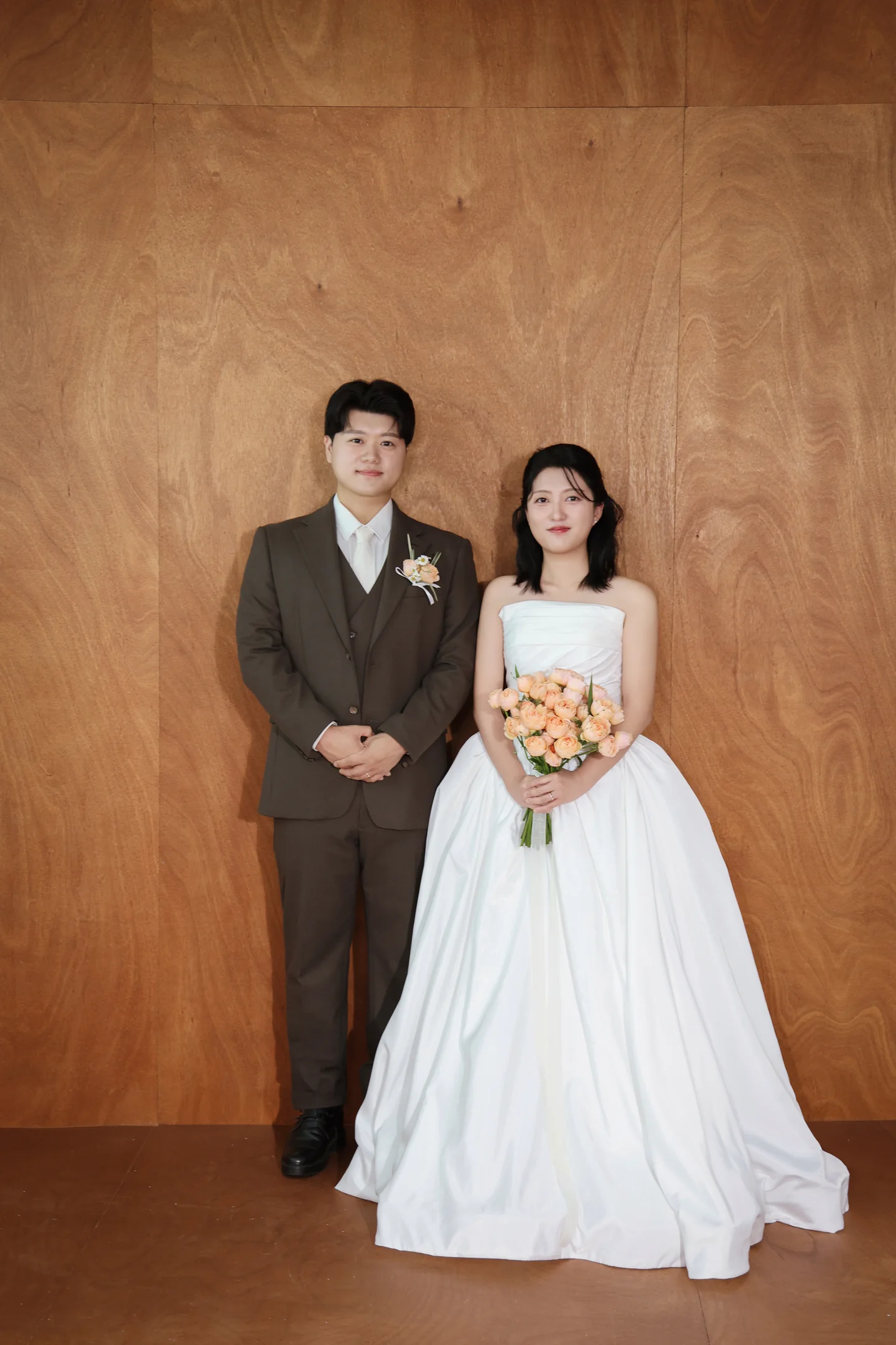 우드 배경 앞에 선 신랑 신부